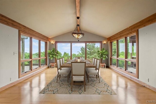 sunroom / solarium featuring lofted ceiling with beams