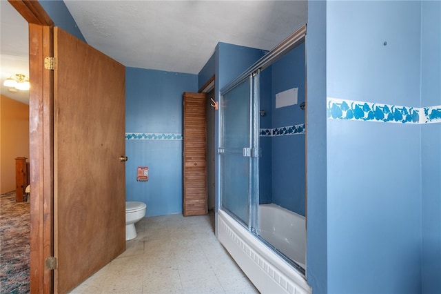 bathroom featuring tile walls, shower / bath combination with glass door, and toilet