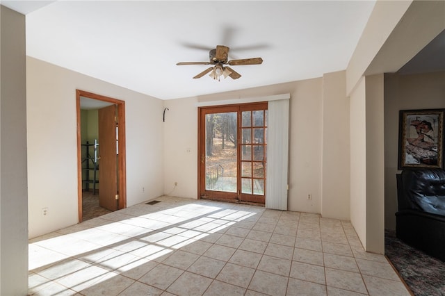 tiled empty room featuring ceiling fan