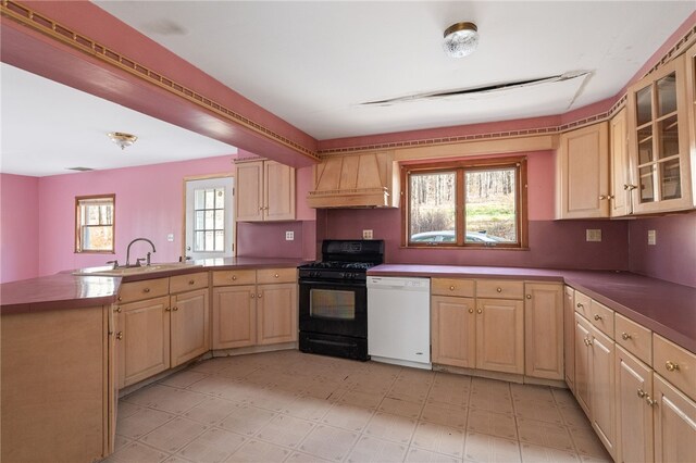 kitchen with sink, custom exhaust hood, black range with gas stovetop, dishwasher, and kitchen peninsula