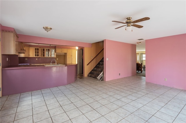 kitchen with light tile patterned flooring, ceiling fan, and kitchen peninsula