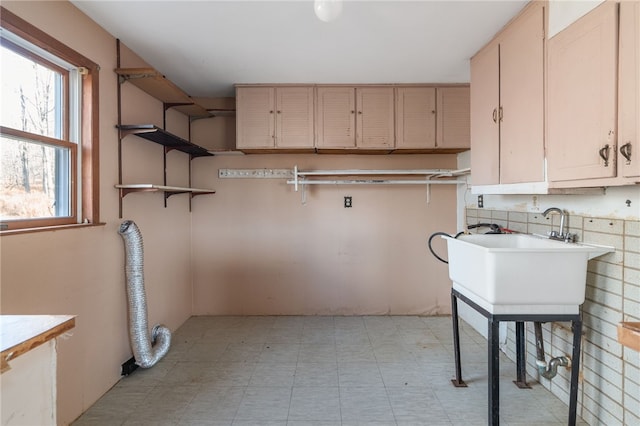 laundry area with cabinets, hookup for an electric dryer, and sink