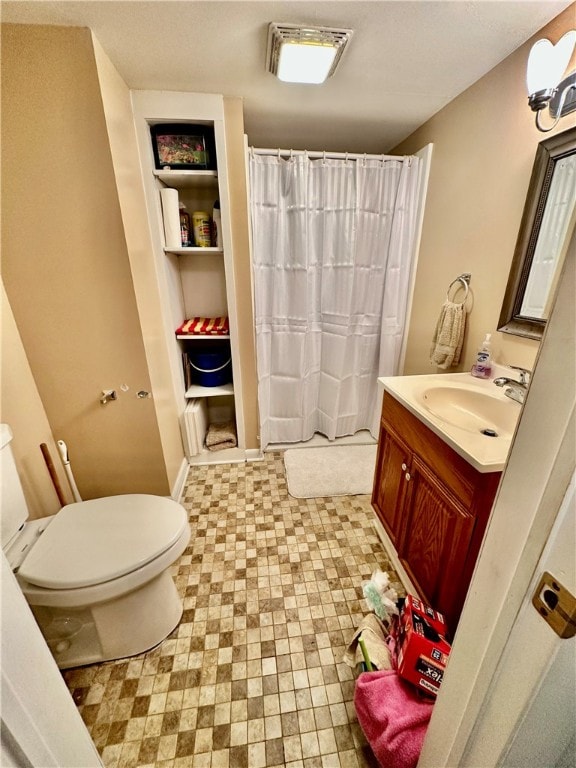 bathroom with vanity, toilet, and curtained shower