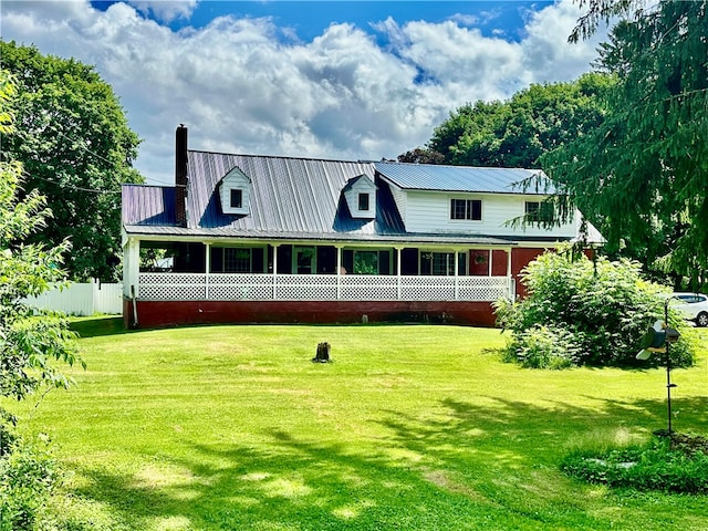 back of property with a yard and a porch