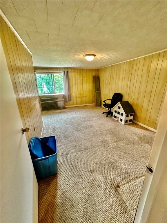 sitting room featuring carpet and wood walls