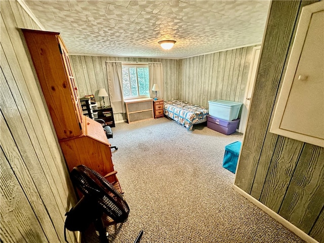 bedroom featuring carpet floors, a textured ceiling, and wood walls