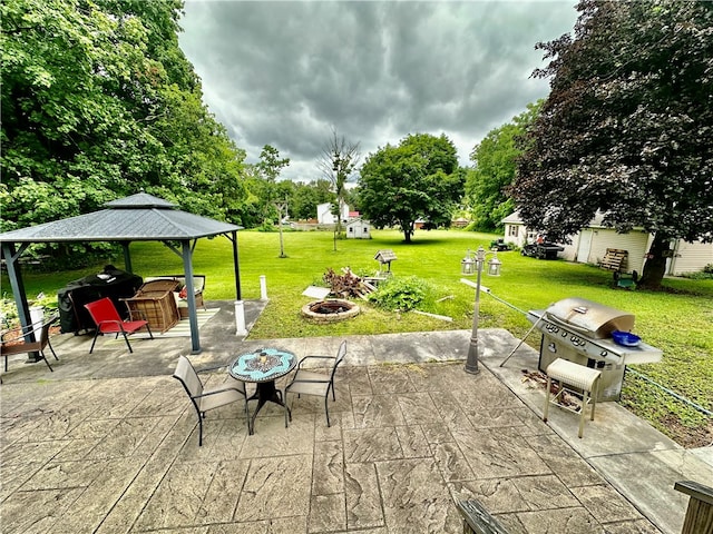 view of patio with area for grilling, a gazebo, and a fire pit