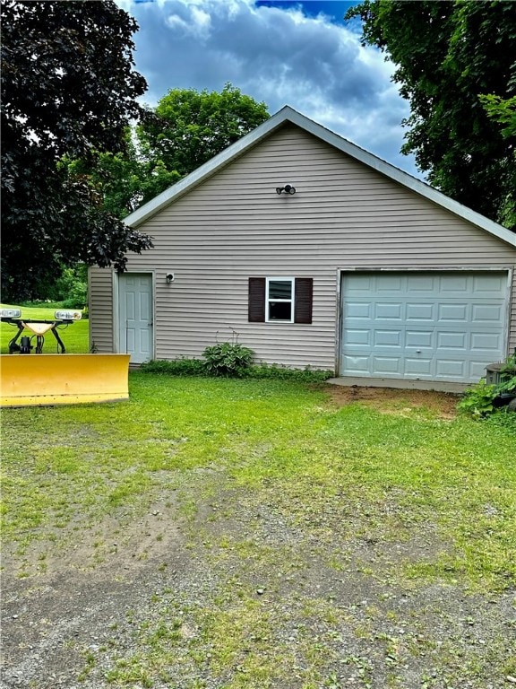 view of side of property with a lawn, an outdoor structure, and a garage