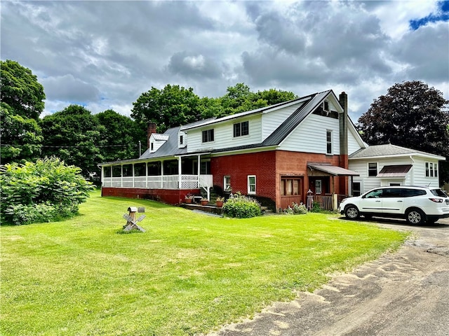 view of front facade with a sunroom and a front lawn