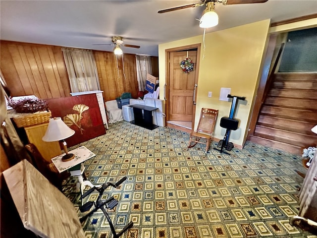 living room featuring wood walls and ceiling fan