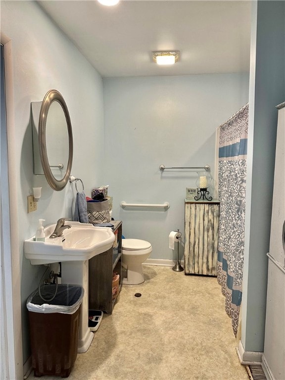 bathroom featuring a shower with curtain and toilet