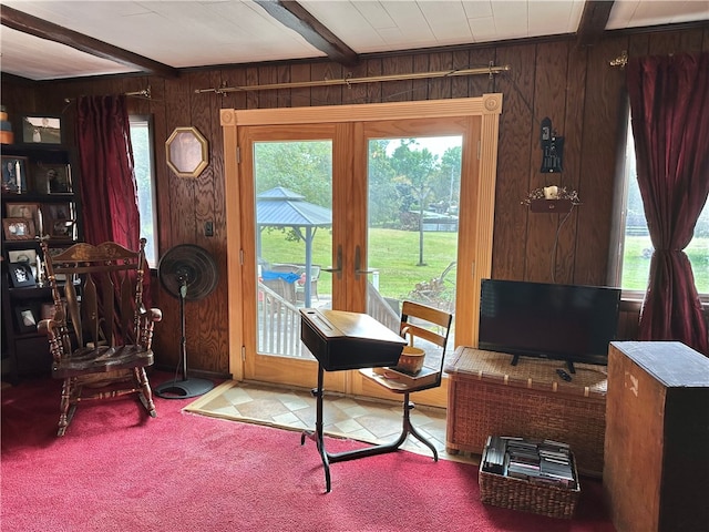 carpeted office featuring wood walls and beam ceiling