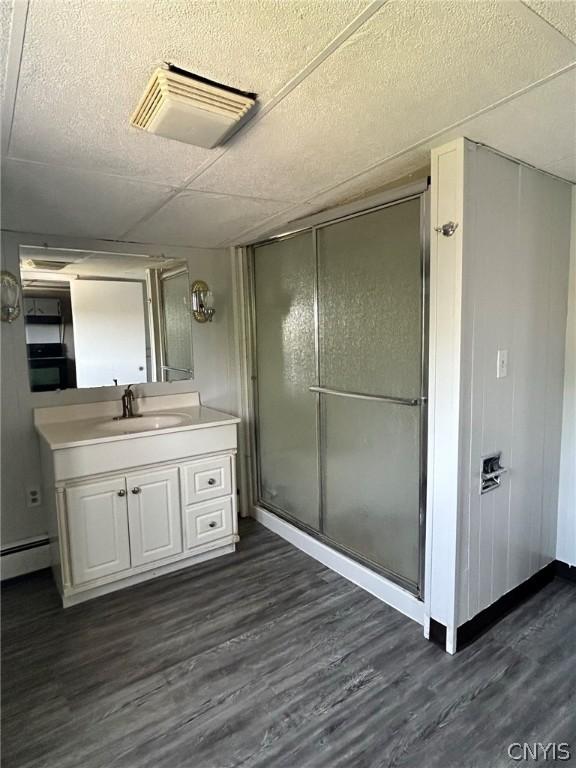 bathroom with visible vents, a stall shower, wood finished floors, and vanity