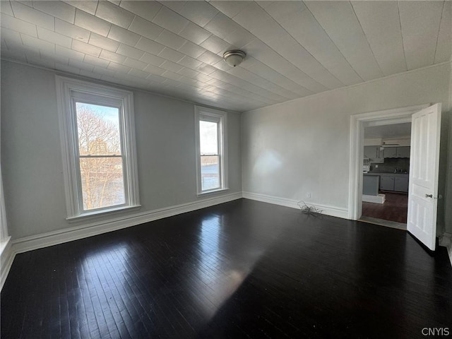 empty room featuring wood-type flooring and baseboards