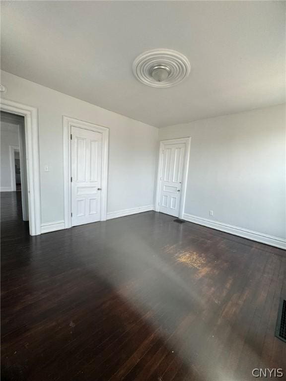 unfurnished bedroom with dark wood-style floors and baseboards