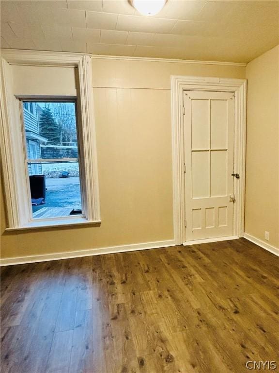 empty room with baseboards and dark wood finished floors