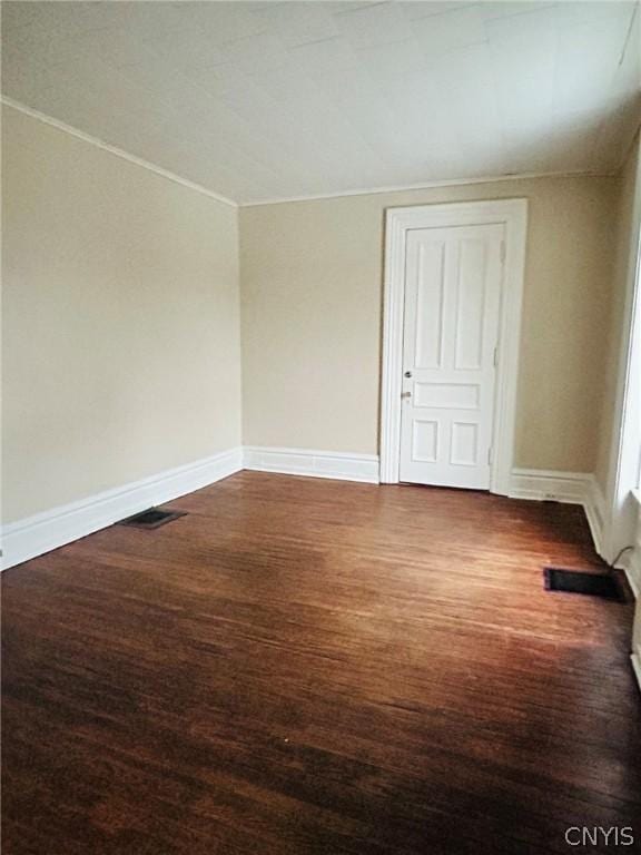 unfurnished room featuring visible vents, baseboards, and wood finished floors