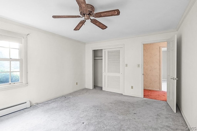 unfurnished bedroom with crown molding, ceiling fan, a baseboard heating unit, light colored carpet, and a closet