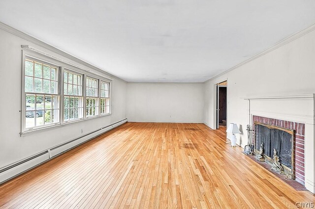 unfurnished living room with light wood-type flooring, a brick fireplace, a baseboard heating unit, and crown molding