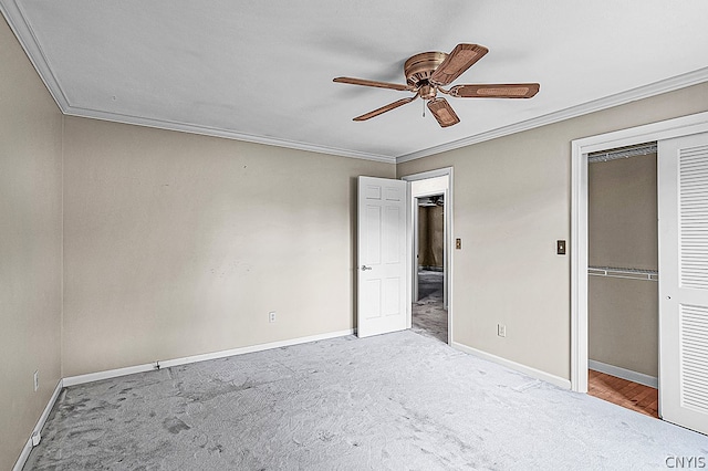 unfurnished bedroom with carpet, a closet, ceiling fan, and ornamental molding