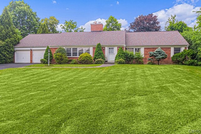 ranch-style house with a garage and a front lawn