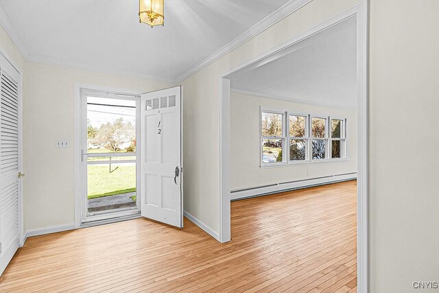 foyer with ornamental molding, baseboard heating, and light hardwood / wood-style flooring