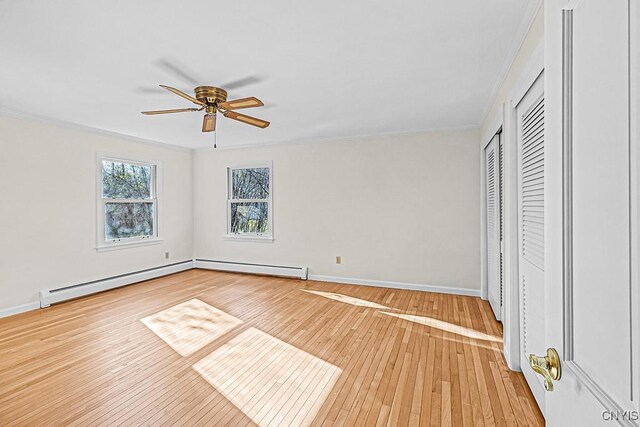 unfurnished bedroom featuring hardwood / wood-style flooring, a baseboard radiator, ceiling fan, and crown molding