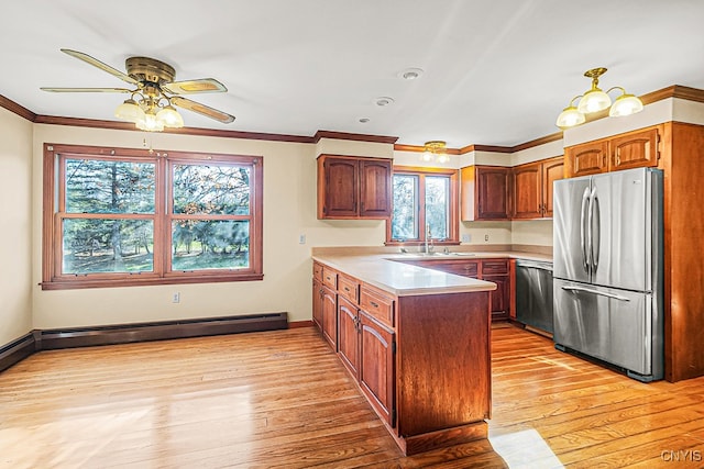 kitchen featuring appliances with stainless steel finishes, light wood-type flooring, ceiling fan with notable chandelier, a baseboard heating unit, and sink