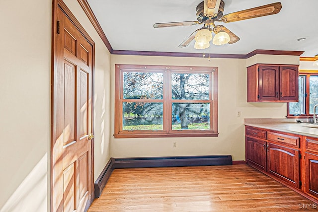 kitchen featuring plenty of natural light, light hardwood / wood-style floors, ceiling fan, and a baseboard radiator