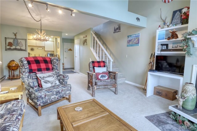 carpeted living room featuring rail lighting and a notable chandelier