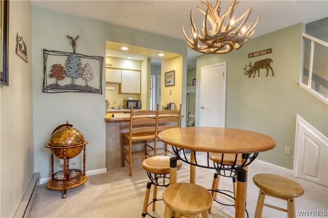 carpeted dining room featuring a chandelier and baseboard heating