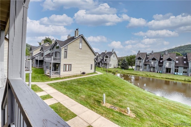 exterior space featuring a lawn and a water view