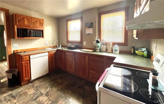 kitchen with dishwasher, range, dark tile flooring, wall chimney exhaust hood, and sink