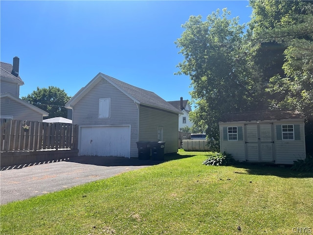 view of home's exterior with a storage unit, a garage, and a lawn