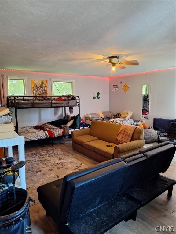 bedroom featuring hardwood / wood-style flooring, ceiling fan, and a textured ceiling