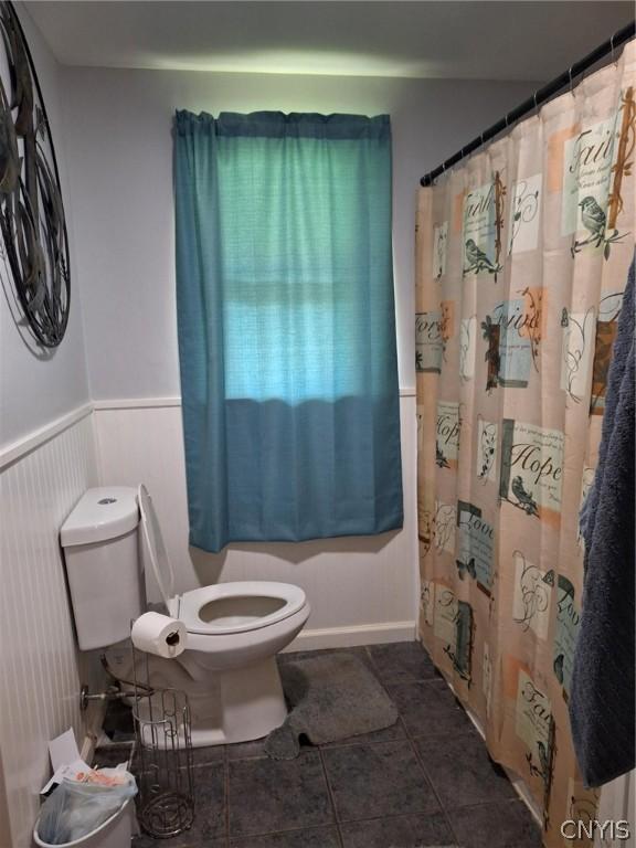 bathroom with curtained shower and toilet