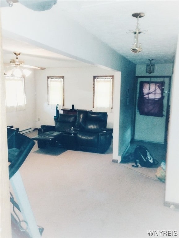 living room featuring carpet, ceiling fan, a healthy amount of sunlight, and a baseboard radiator