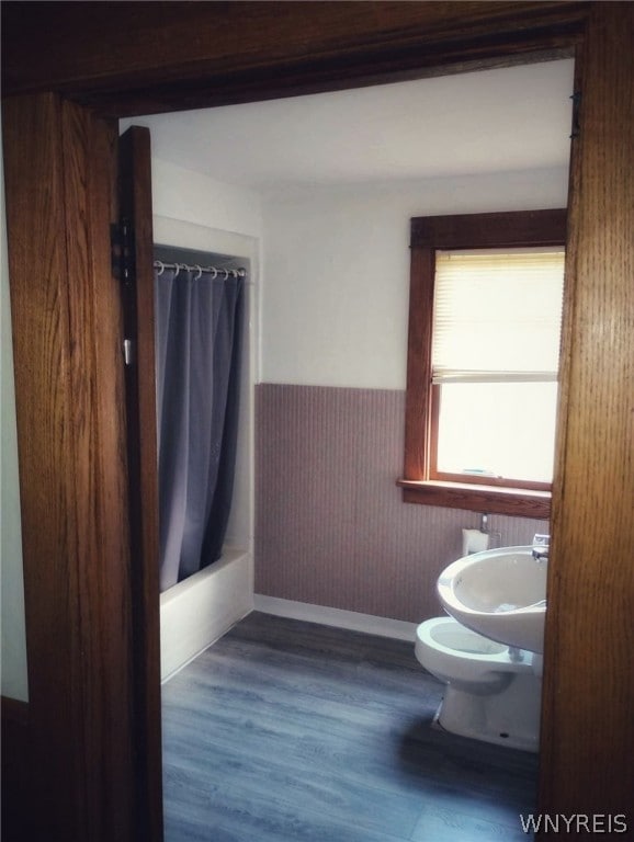 full bathroom with sink, hardwood / wood-style flooring, toilet, and shower / bath combo with shower curtain