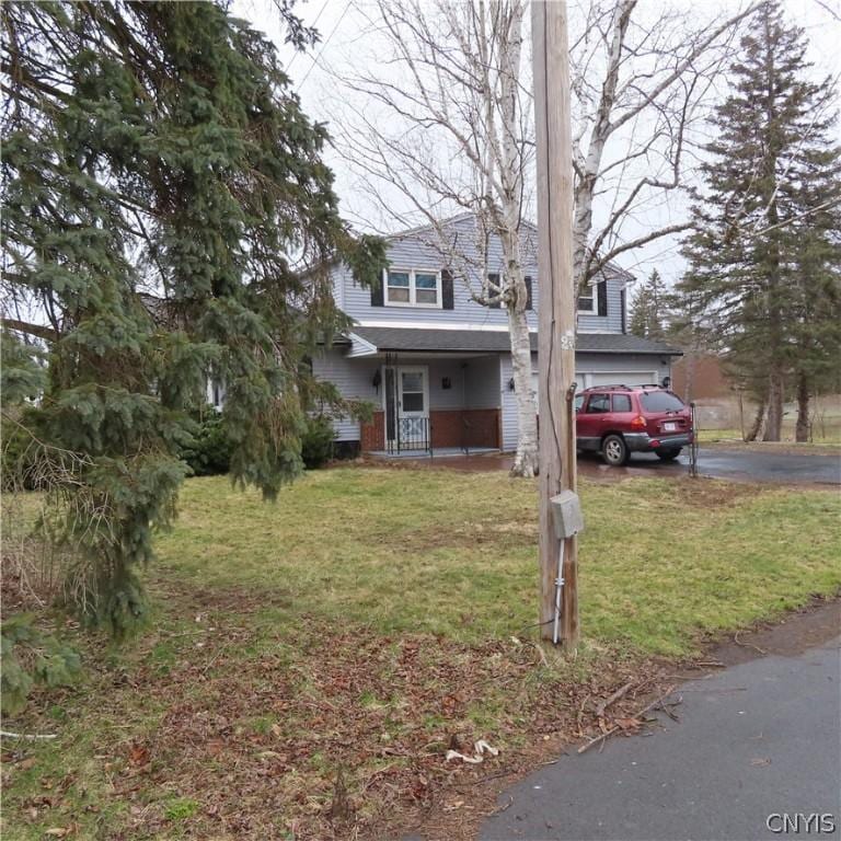 view of front of property with a front lawn, a porch, and a garage