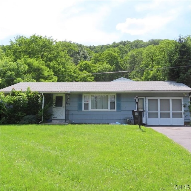 single story home featuring a garage and a front lawn