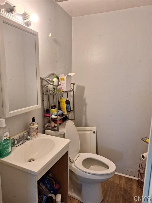 bathroom with hardwood / wood-style floors, vanity, and toilet