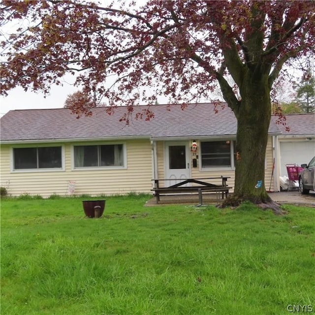 view of front of home with a front yard and a garage