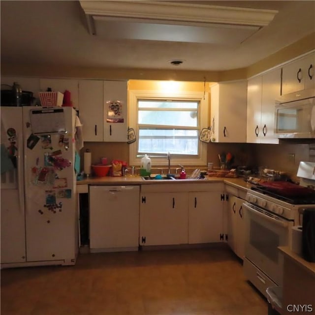 kitchen with white cabinetry, white appliances, and sink