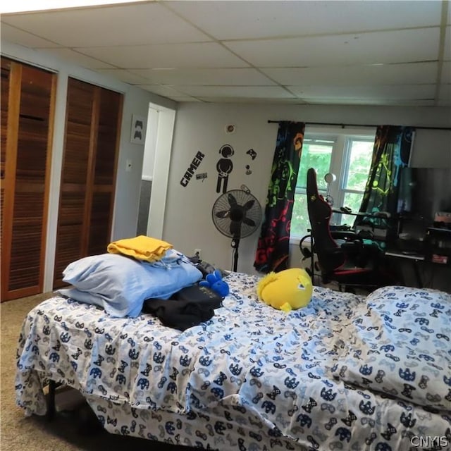 bedroom with a drop ceiling and multiple closets