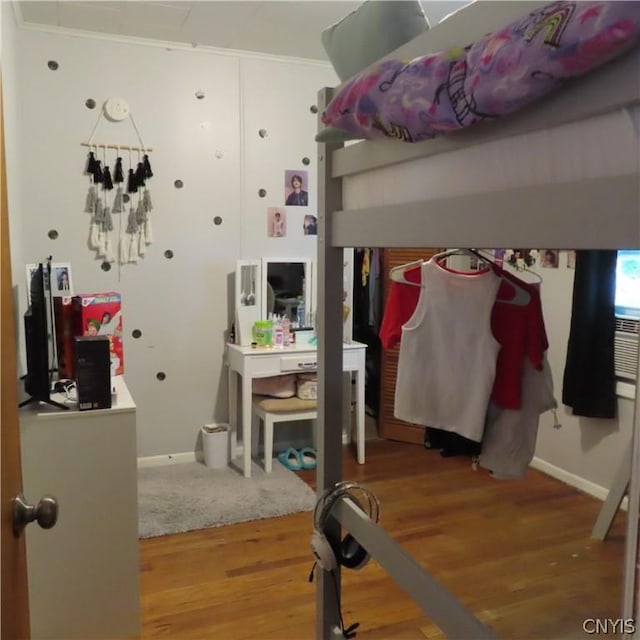 bedroom with hardwood / wood-style flooring and ornamental molding