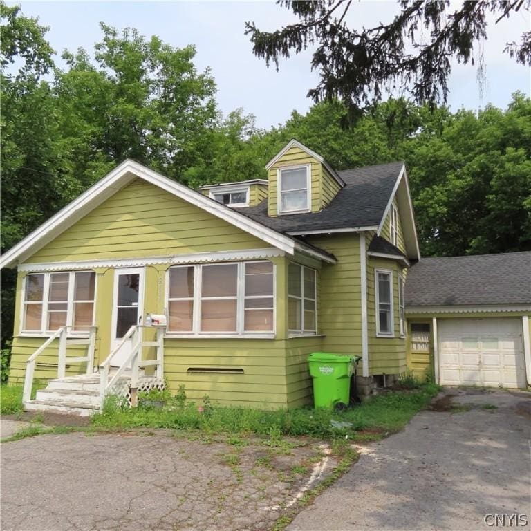 2404 Brewerton Rd, Salina, NY 13211 - view of front of house featuring entry steps, an attached garage, aphalt driveway, and roof with shingles