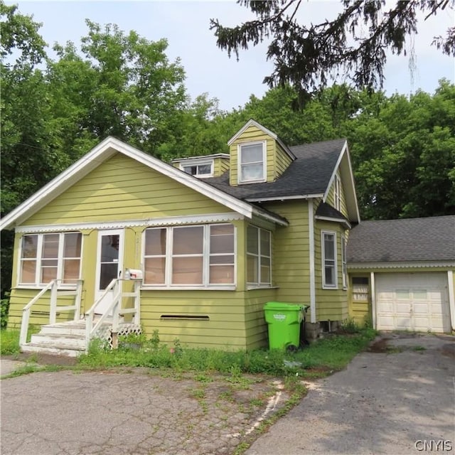 view of front of house featuring entry steps, an attached garage, aphalt driveway, and roof with shingles