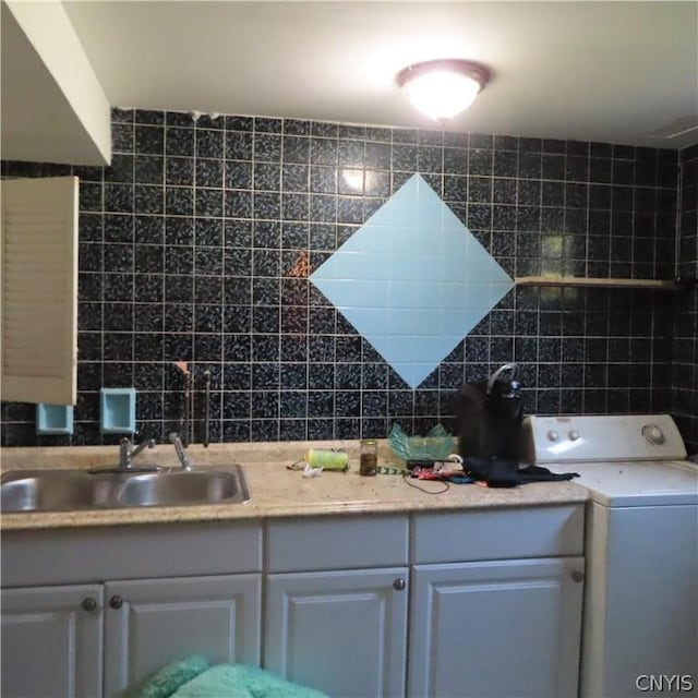 bathroom with sink, washer / dryer, backsplash, and tile walls