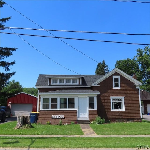 view of front facade featuring an outbuilding, a front yard, and a garage