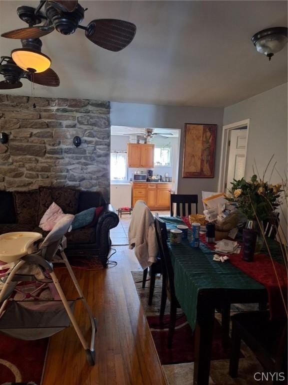 dining space with wood-type flooring and ceiling fan